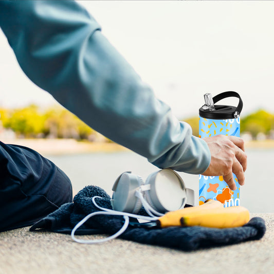 Decorated sport bottle with a handle cap beside exercise accessories outdoors